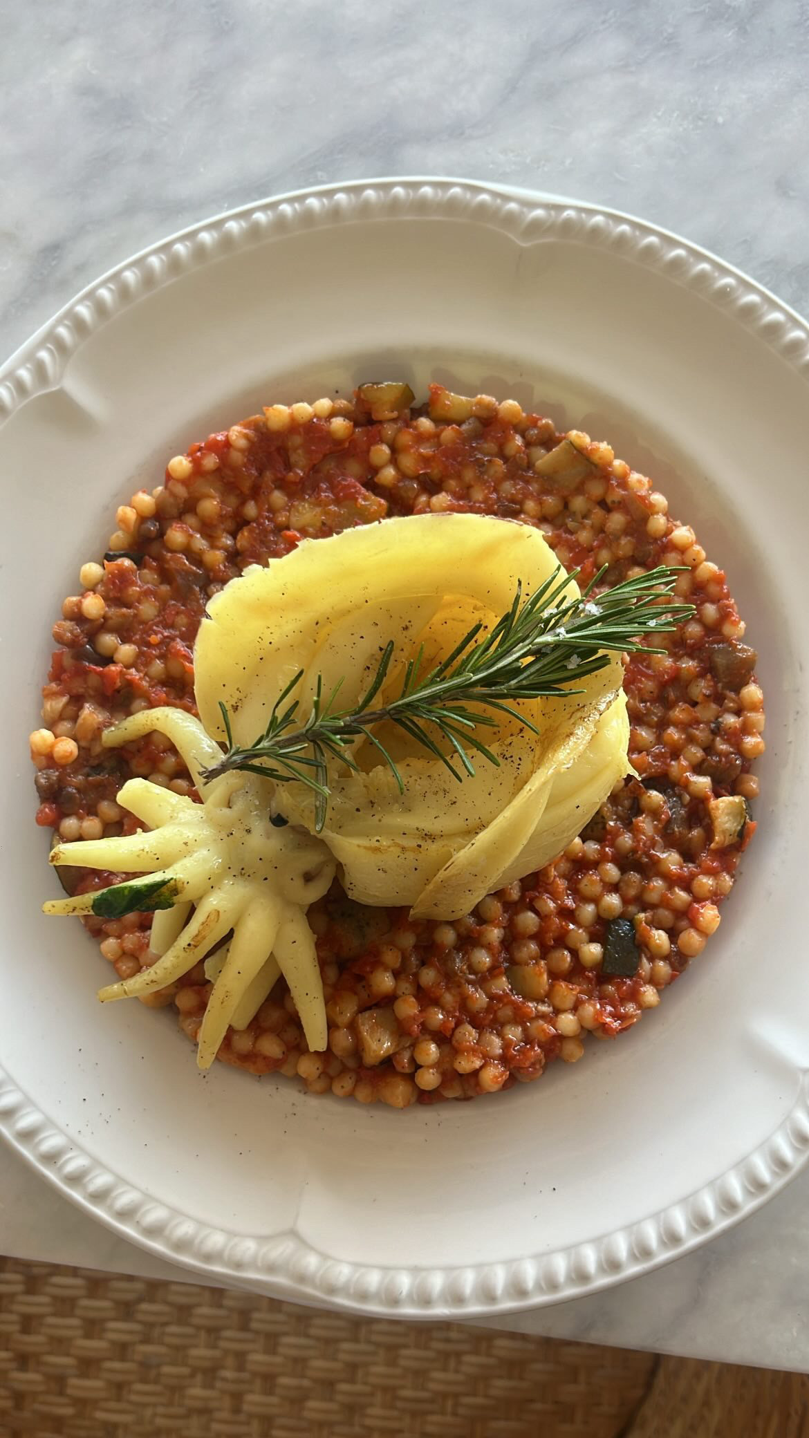 Perles de couscous aux légumes, rose de pomme de terre et romarin
